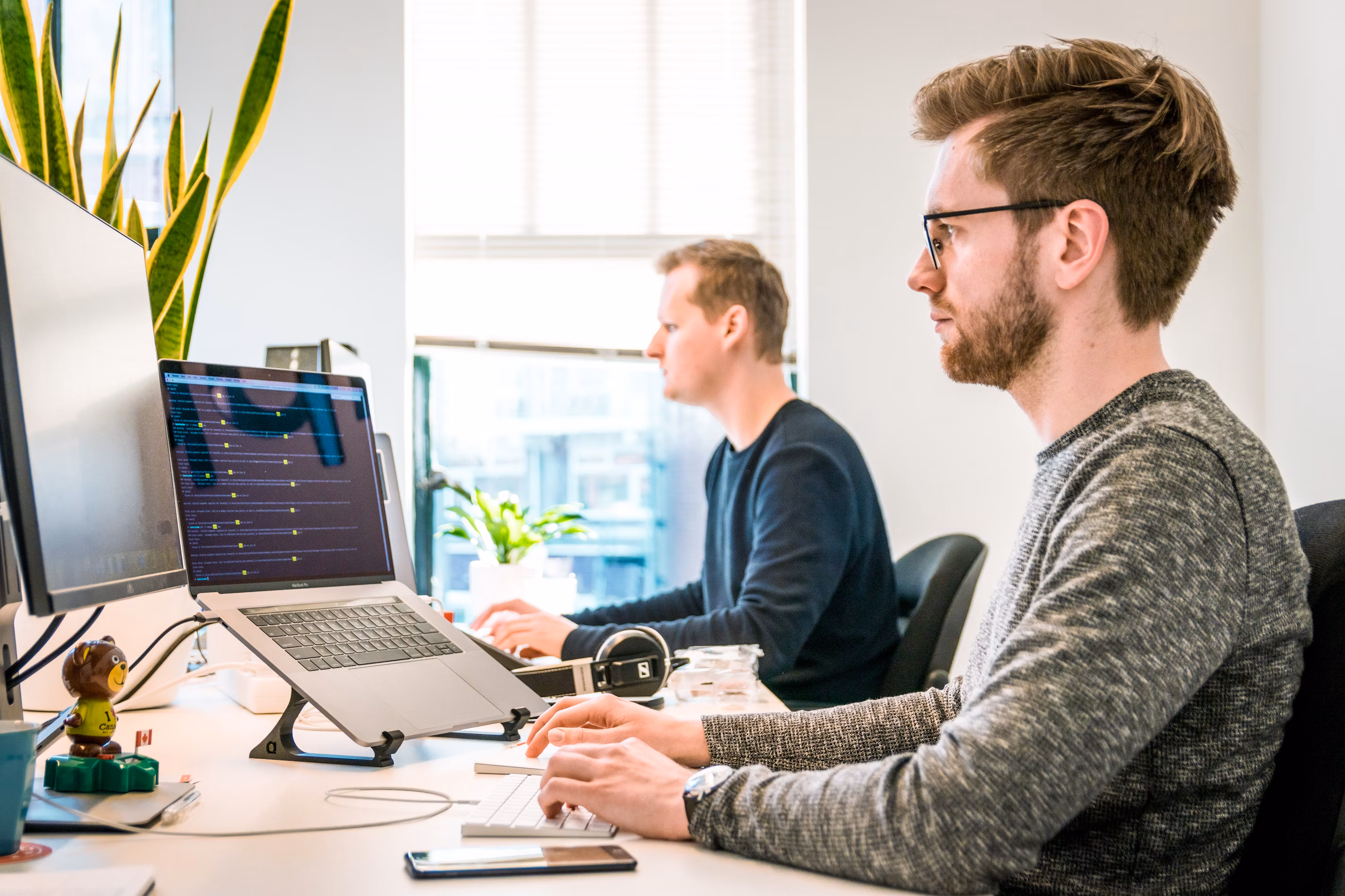 Team of developers working together on computers in a modern tech office